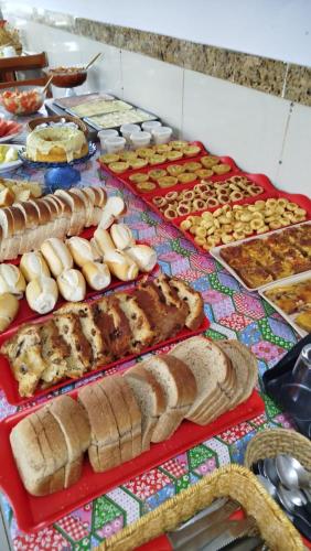 a table with many different types of bread and pastries at Villa Mar Boa Viagem in Recife