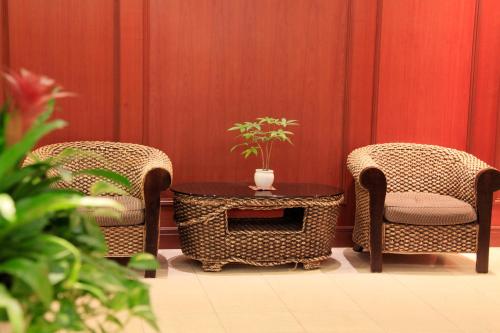 two wicker chairs and a table with a potted plant at Quintessa Hotel Sasebo in Sasebo