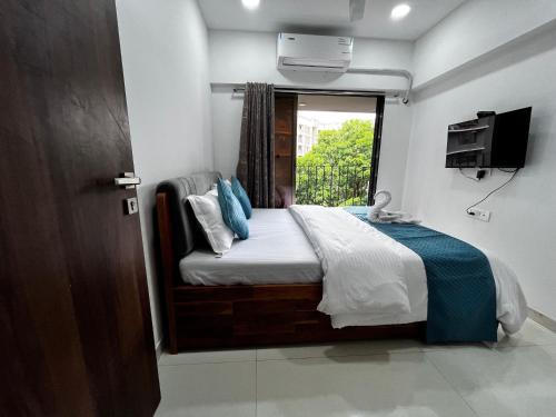 a bedroom with a bed with a window and a television at Zenith Suites & Service Apartments - Powai in Mumbai