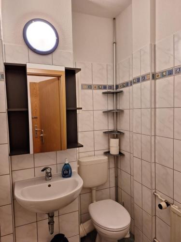 a bathroom with a toilet and a sink and a window at Nordstraße 4 - Ferienwohnung für 2 Personen in Neukieritzsch in Neukieritzsch