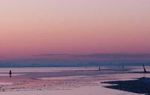 a person walking on the beach at sunset at Schreinerhaus in Vitte