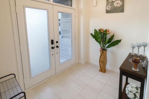a hallway with a french door and a vase of flowers at 2024 Built Elegant 3BR Kleinburg Vaughan Townhouse with Free Parking, WiFi, Full Kitchen, Laundry, Near Canada's Wonderland! Perfect for Family Travel, Group Trips or Work Stays! in Vaughan