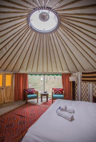 a bedroom with a bed in a yurt at Roomy Mountain Top Resort, Batakundi in Battakundi