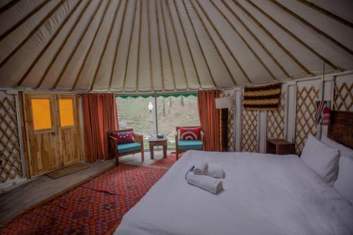 a bedroom with a bed in a yurt at Roomy Mountain Top Resort, Batakundi in Battakundi