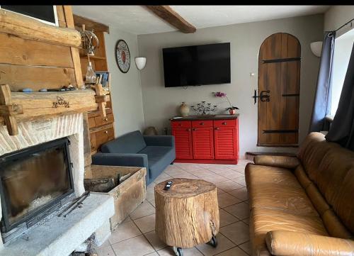 a living room with a fireplace and a tv at La chanvrière in Beaulieu-sur-Loire