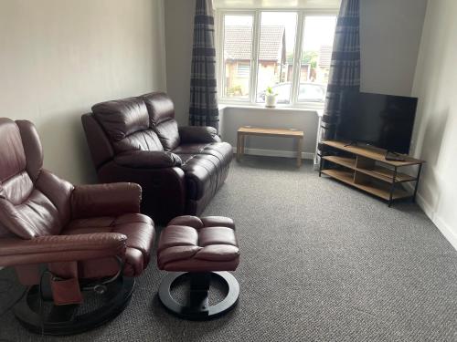a living room with a couch and a chair and a television at Cosy bungalow Branton Doncaster near Yorkshire wildlife park and doncaster centre in Cantley
