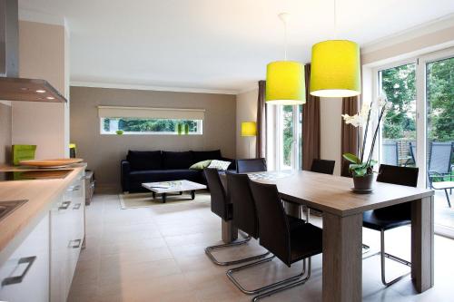 Una cocina y una sala de estar con mesa y sillas. en die Strandhäuser - Meeresrauschen, en Ostseebad Sellin
