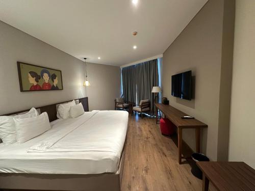 a hotel room with a bed and a desk at Apec Mandala wyndham Apartment - APEC Mui Ne in Mui Ne