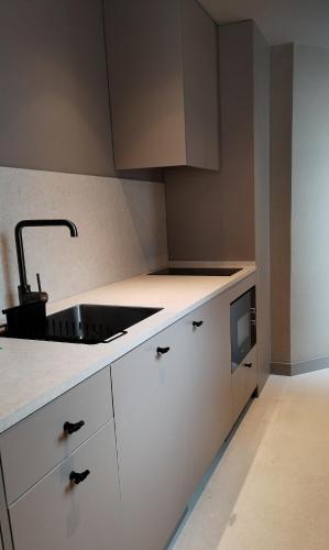 a white kitchen with a sink and a microwave at Aparthotel Atenea Calabria in Barcelona