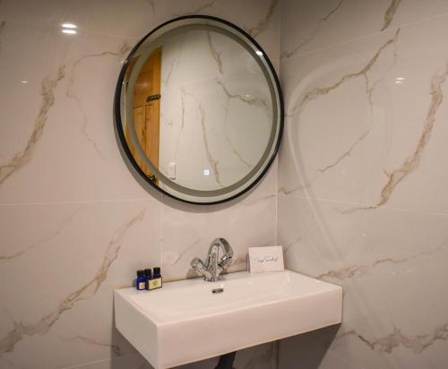 a bathroom with a sink and a mirror at Roomy Mountain Top Resort, Batakundi in Battakundi
