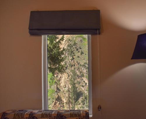 a window with a view of a mountain at Roomy Mountain Top Resort, Batakundi in Battakundi