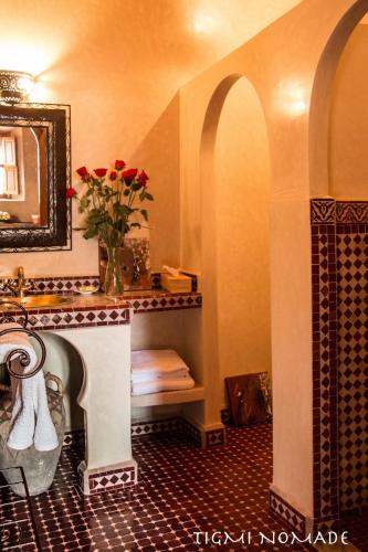 a bathroom with a vase of flowers on a fireplace at Tigmi Nomade in Tahannout