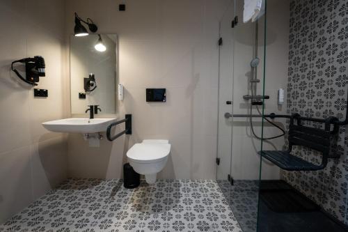 a bathroom with a toilet and a sink and a shower at De Brauhotel - Hôtel de la Brasserie Nationale in Bascharage
