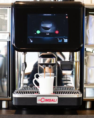 a coffee maker with a cup of coffee at De Brauhotel - Hôtel de la Brasserie Nationale in Bascharage