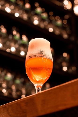a glass of beer sitting on top of a counter at De Brauhotel - Hôtel de la Brasserie Nationale in Bascharage