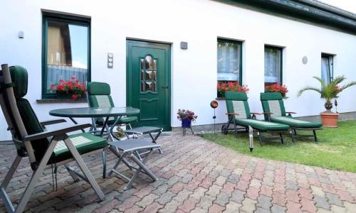 un groupe de chaises et une table devant un bâtiment dans l'établissement "Das Ferienhaus Waren" Objekt ID 12035-8, à Waren