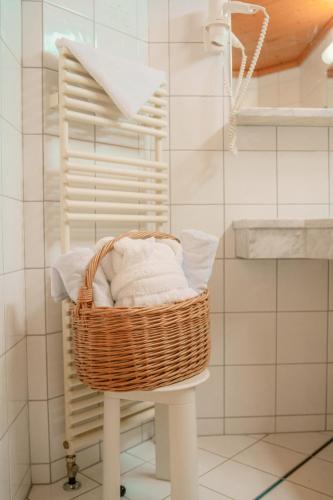 a wicker basket sitting on a stool in a bathroom at Hotel Glemmtalerhof in Saalbach Hinterglemm