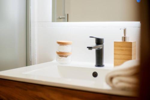 a bathroom sink with a soap dispenser on it at Casa Cosmos Arcade WiFi 4 Huéspedes in Zaragoza