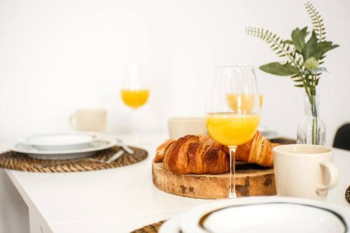 a table with a glass of orange juice and croissants at Casa Cosmos Arcade WiFi 4 Huéspedes in Zaragoza