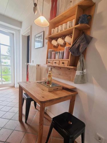 a kitchen with a wooden table and a shelf at Haus Kliffkante 1 Goting in Goting