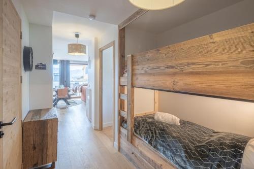 ein Schlafzimmer mit einem großen hölzernen Etagenbett in der Unterkunft Alpe d'Huez Houses - Chez Cathy - Fermes de l'Alpe - Fabuleux 2 chambres neuf pour 6 personnes in L'Alpe-d'Huez