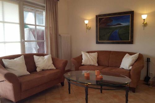 een woonkamer met 2 banken en een glazen tafel bij Hochstieg 32, Gonska, Haushälfte in Nieblum