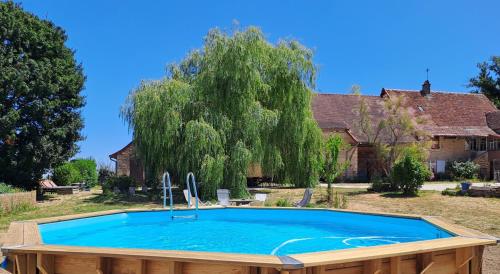 une grande piscine devant une maison dans l'établissement La Chavoche gîte, à La Chapelle-de-Bragny