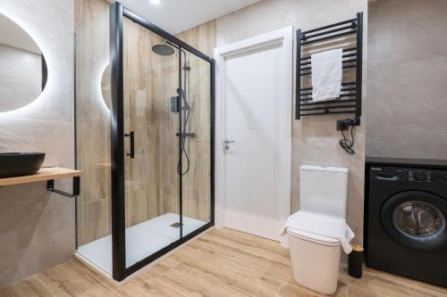 a bathroom with a shower and a washing machine at Bilbao Loft Apartments in Bilbao