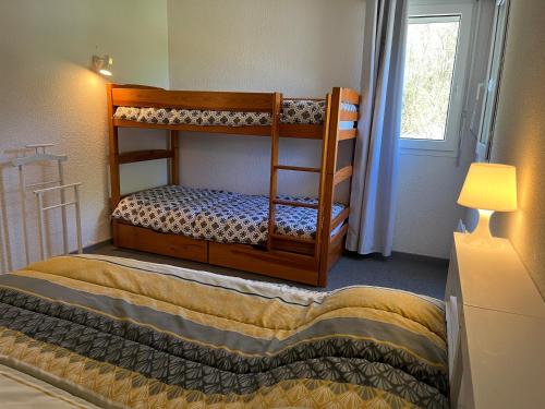 deux lits superposés dans une chambre avec fenêtre dans l'établissement Appartement 20, avec balcon, Résidence de l'Ars, à Aulus-les-Bains