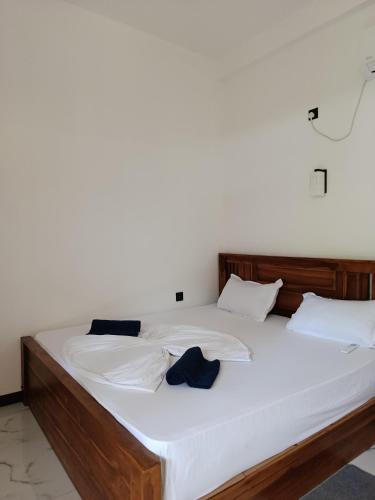a bed with white sheets and blue pillows on it at Elite Bay Arugambay in Arugam Bay