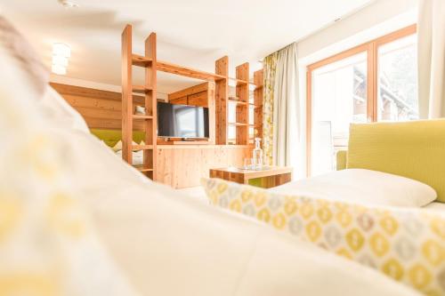 a hotel room with a bed and a tv at Hotel Glemmtalerhof in Saalbach Hinterglemm