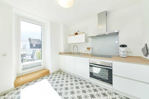 a kitchen with white cabinets and a window at NEU!!! Moselbleibe Ferienhaus 1903 in Bernkastel-Kues