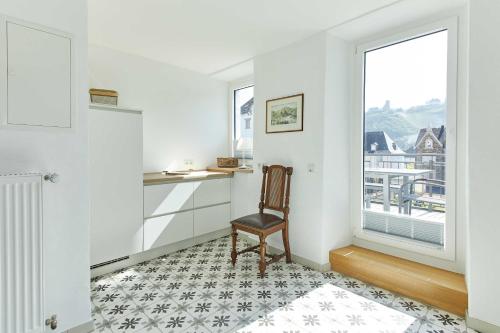 a white room with a chair and a window at NEU!!! Moselbleibe Ferienhaus 1903 in Bernkastel-Kues