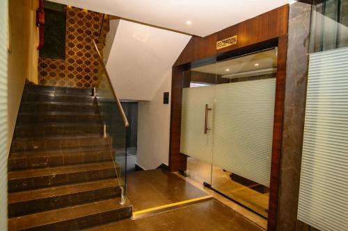 a staircase leading to a building with a glass door at Urvi Banquets & Guest House in kolkata