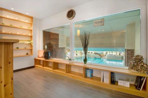 a room with a large window and a table with books at Appartement Hella Wahnsinn in Sankt Englmar
