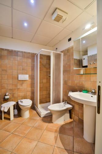 a bathroom with a toilet and a shower and a sink at La Lanterna in San Vincenzo