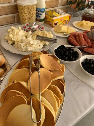 コブレチにあるglory hotel kobuletiのチーズやその他の食べ物が載った皿が置かれたテーブル