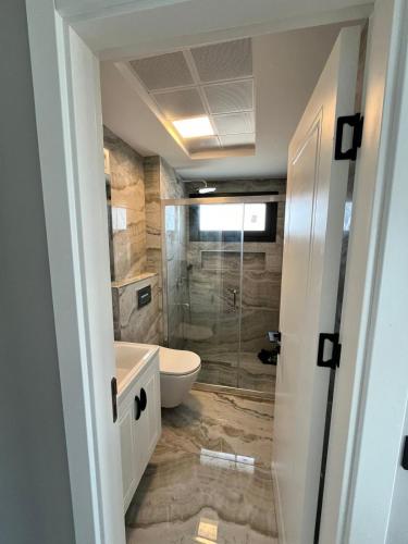 a bathroom with a tub and a toilet and a shower at Villa Ant in Çeşme