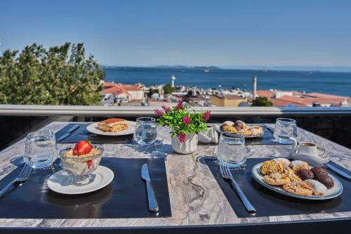 a table with plates of food and a view of the ocean at Four-G Hotel Premium in Istanbul