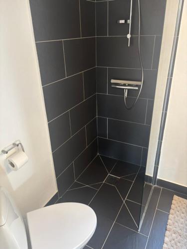 a bathroom with a shower with a toilet at Ny lækker lejlighed på Havnen in Thyborøn