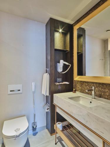 a bathroom with a sink and a toilet and a mirror at Four-G Hotel Premium in Istanbul