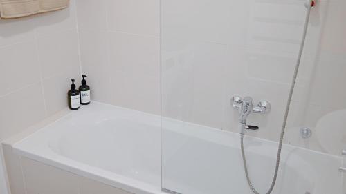 a shower with two bottles of wine in a bathroom at Apartment SOFI Belville in Novi Beograd