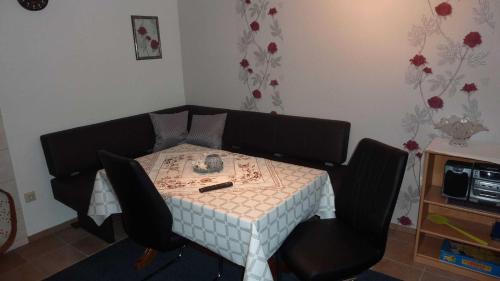 a table with two chairs and a table with a phone on it at FeWo Sassen in Ihlow