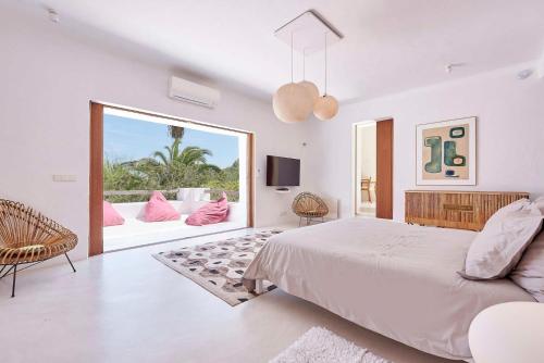 a white bedroom with a bed and a large window at Elegant Villa Retreat in Ibiza's Heart, 1041 in Sant Josep de Sa Talaia