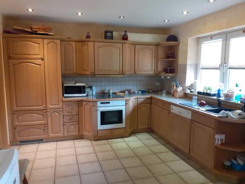 a kitchen with wooden cabinets and a stove top oven at Ferienwohnung Teschow in Teschow