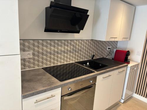 une cuisine avec un évier et un micro-ondes dans l'établissement maison proche plage et centre ville, à Les Sables-dʼOlonne