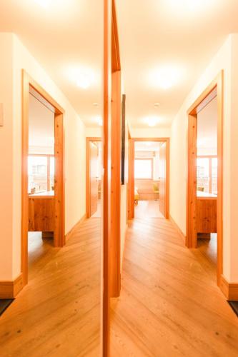 a hallway of a house with wooden floors and windows at Hotel Glemmtalerhof in Saalbach Hinterglemm