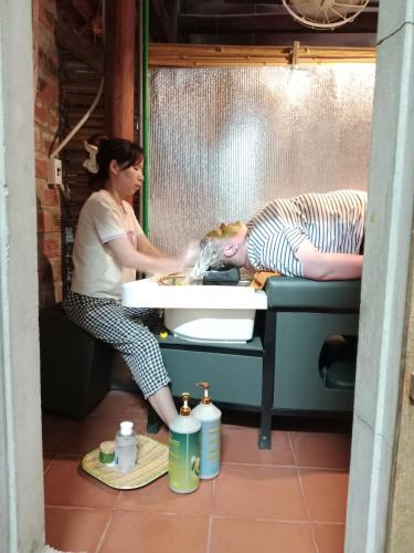 a woman is washing her head in a sink at Phong Nha Magic Fingers Homestay and Spa in Phong Nha