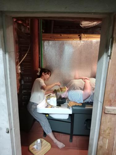 two people cooking in a kitchen with a sink at Phong Nha Magic Fingers Homestay and Spa in Phong Nha