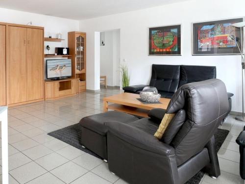 Una sala de estar con un sofá de cuero y una mesa. en Haus am Meer, Whg D06, en Boltenhagen
